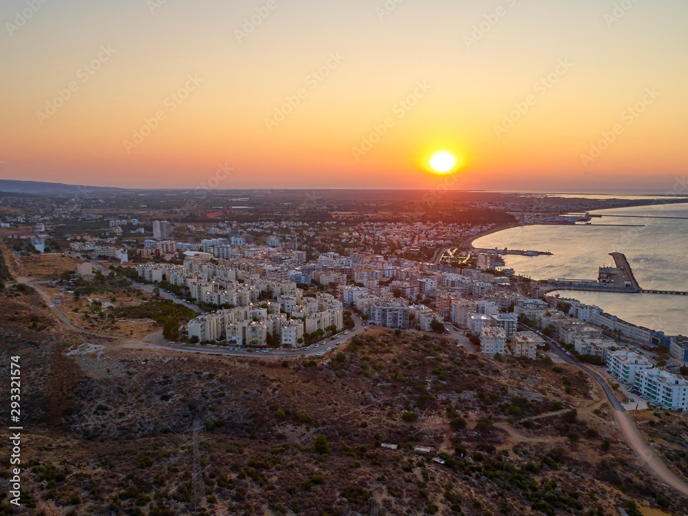 The sun rises over the seaside town. Aerial view of town, sea and harbor