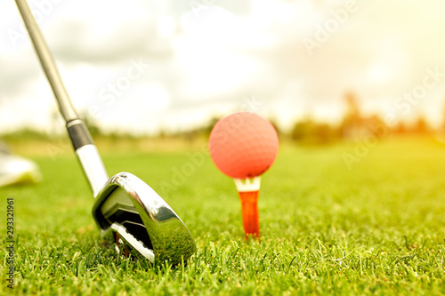 Close up view of golf clubs and golf balls on a green lawn in a beautiful golf course with morning sunshine. photo