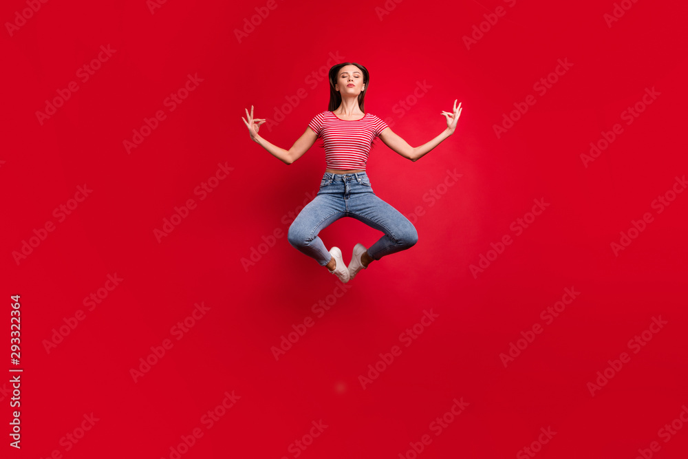 Full length body size photo of practicing girlfriend wearing jeans denim striped t-shirt while isolated over red background