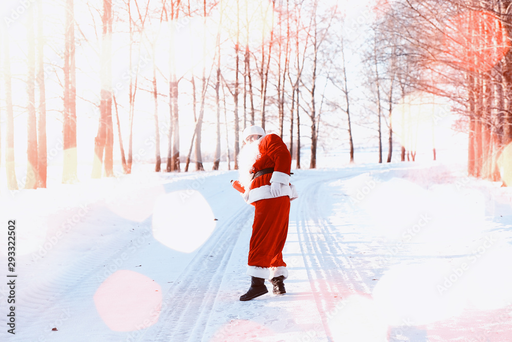 Santa in the winter field. Santa magical fog is walking along the field. Santa on Christmas Eve is carrying presents to children in a red bag. Santa in the winter field. Santa magical fog is walking along the field. Santa on Christmas Eve is carrying presents to children in a red bag.