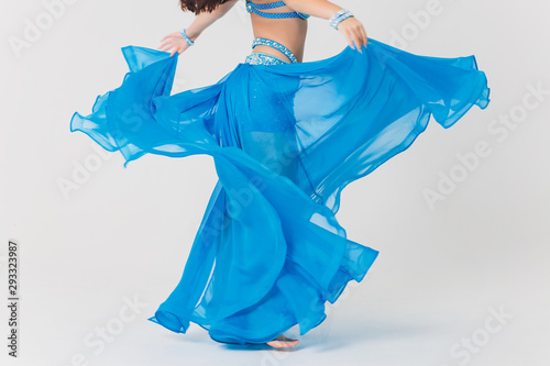 Fotografi Portrait of belly dancer girl in blue. isolated on white.
