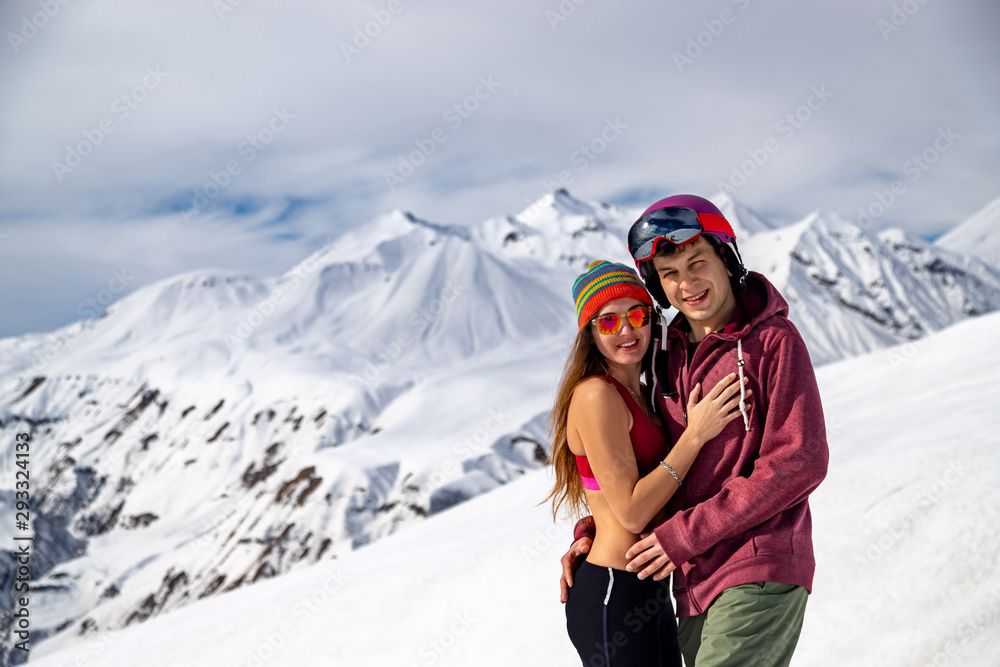 Young happy couple in snowy mountains. Winter sport vacation