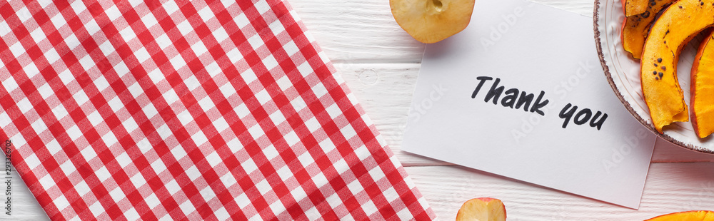 top view of pumpkin, ripe apples and thank you card on wooden white table with plaid napkin, panoramic shot top view of pumpkin, ripe apples and thank you card on wooden white table with plaid napkin, panoramic shot
