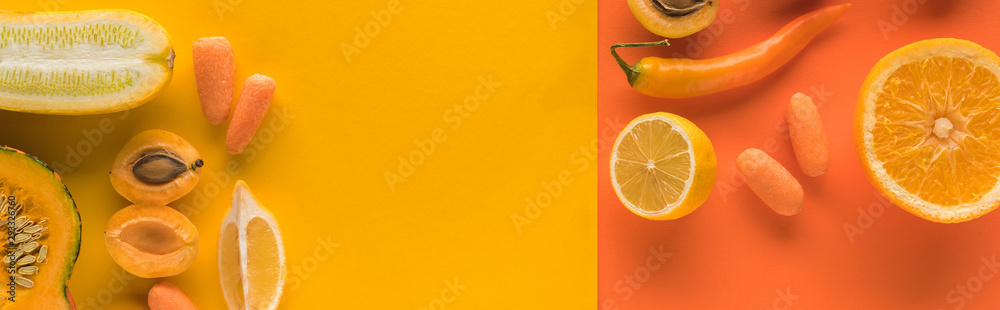 top view of yellow fruits and vegetables on orange background with copy space, panoramic shot