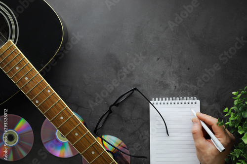 Guitar and accessories on a stone background. Desk musician, headphones, microphone. photo