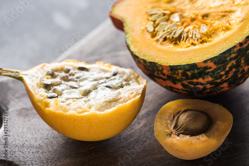 close up view of yellow sweet granadilla, pumpkin and apricot on wooden chopping boards photo