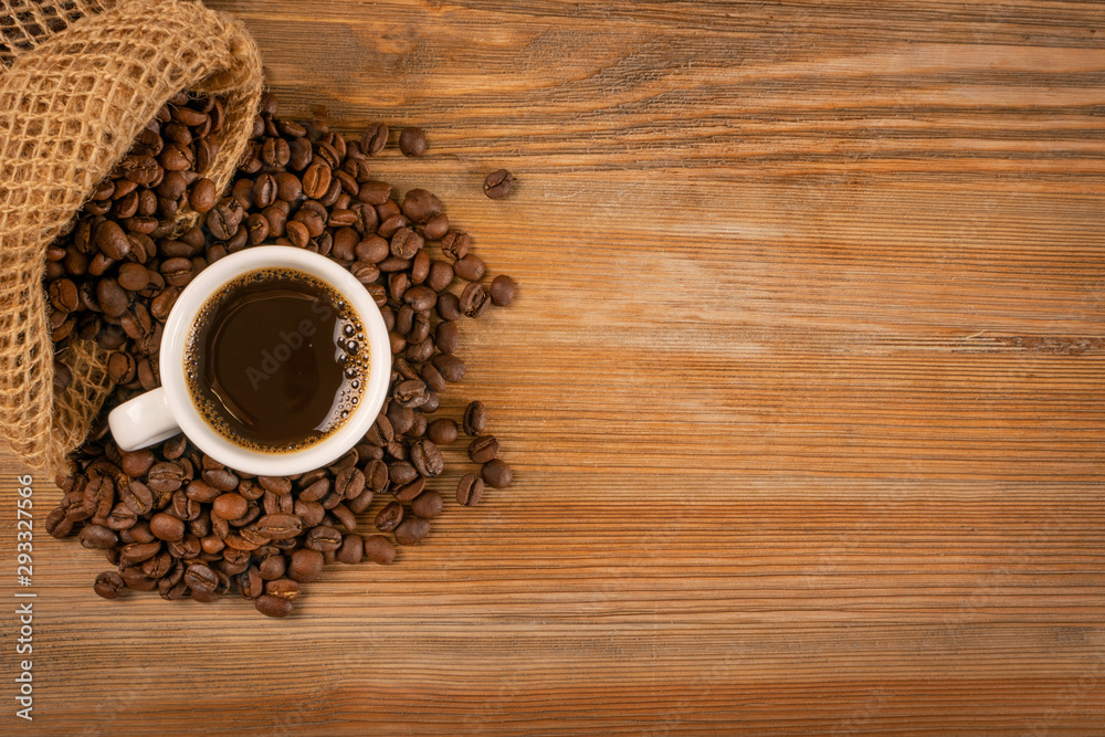 Hot coffee cup and coffee beans on brown background top view Hot coffee cup and coffee beans on brown background top view