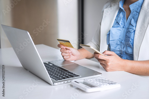Young woman consumer holding smartphone  credit card and typing on laptop for online shopping and payment make a purchase on the Internet  Online payment  networking and buy product technology
