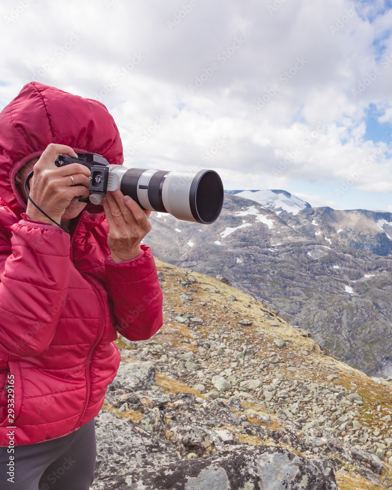 Tourist taking photo fin norwegian mountains