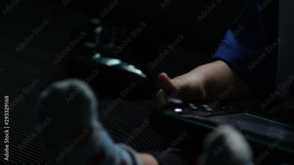 young child boy toddler with controller playing electronic TV video games on sofa wearing fireman pants socks jersey new generation technology hand–eye coordination skills gaming adiction young child boy toddler with controller playing electronic TV video games on sofa wearing fireman pants socks jersey new generation technology hand–eye coordination skills gaming adiction