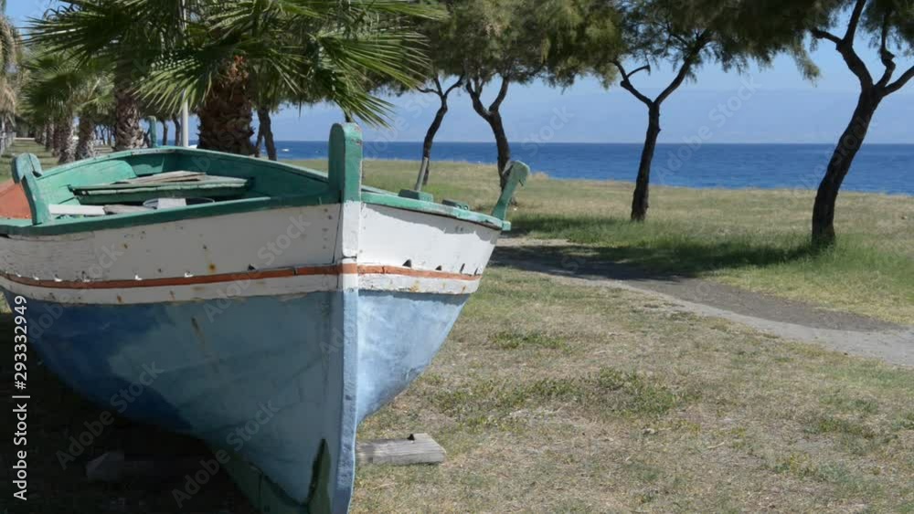 typical wooden fishing boat just steps from the shore on a sunny and windy day typical wooden fishing boat just steps from the shore on a sunny and windy day