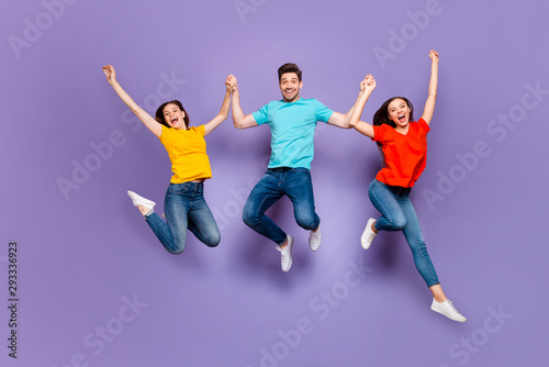 Full length size body photo of three group person having funny mood raising hands up dreams come true isolated violet background