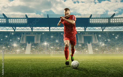 Soccer player in action. Run with a ball. Soccer stadium with cheering fans © TandemBranding