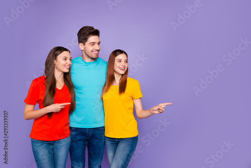 Portrait of nice attractive lovely friendly charming content cheerful cheery glad guys wearing colorful t-shirts denim pointing aside solution ad advert isolated over violet lilac background