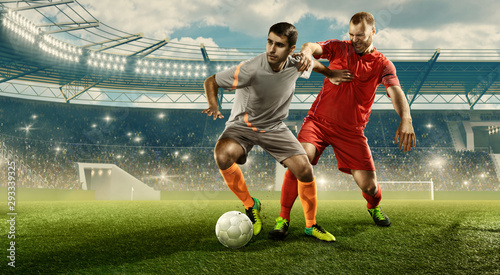 Two professional soccer players fight for the ball during the game. Stadium with cheering fans © TandemBranding