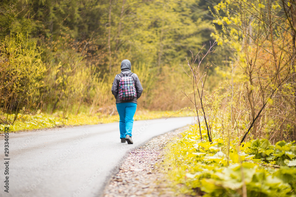 Fototapeta premium Hiking. Senior 60 years old woman hiker smiling walk in autumn forest. Active retirement concept