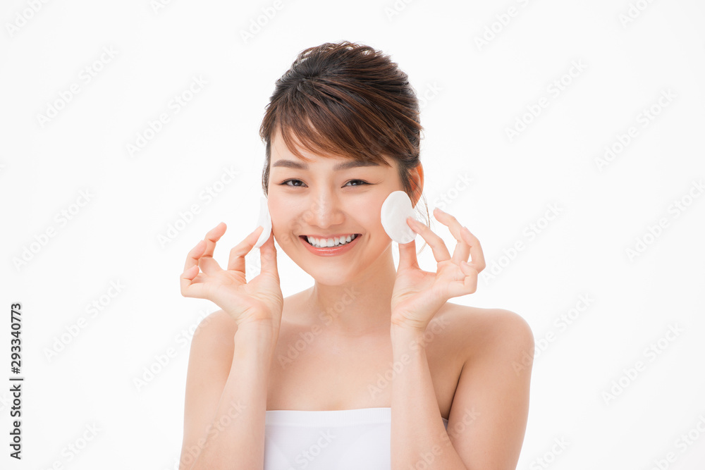 Asian woman with fair perfect healthy glow skin hands hold cotton pad cleansing face isolated on white Asian woman with fair perfect healthy glow skin hands hold cotton pad cleansing face isolated on white