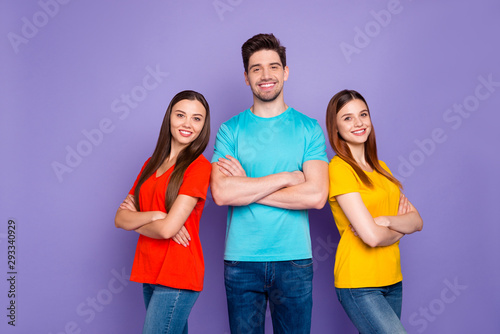 Portrait of nice attractive lovely charming cheerful cheery content guys wearing colorful t-shirts jeans denim supporting each other gathering teamwork isolated over violet lilac background