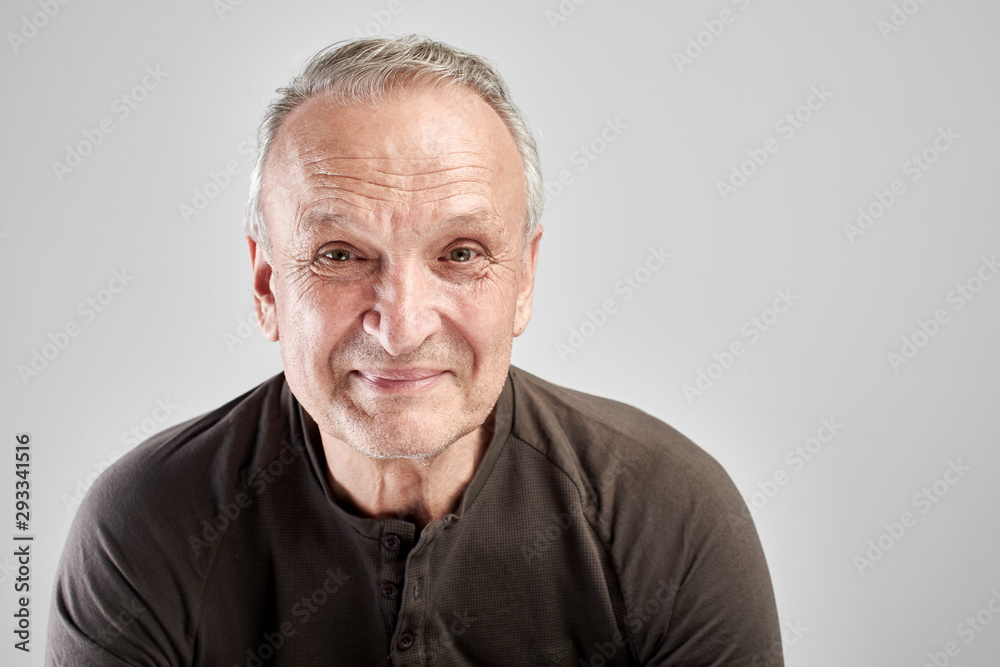 Portrait of a Caucasian elderly man smiling on a white studio background. Handsome gray-haired old pensioner with a friendly kind face Portrait of a Caucasian elderly man smiling on a white studio background. Handsome gray-haired old pensioner with a friendly kind face