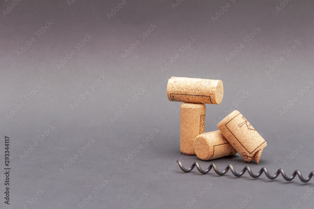 Wine corks with corkscrew on black background. Free copy space.