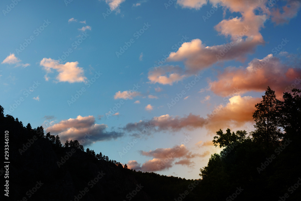 silhouette image of mountain. white clouds in the sunset sky on a background. sunset in the mountains