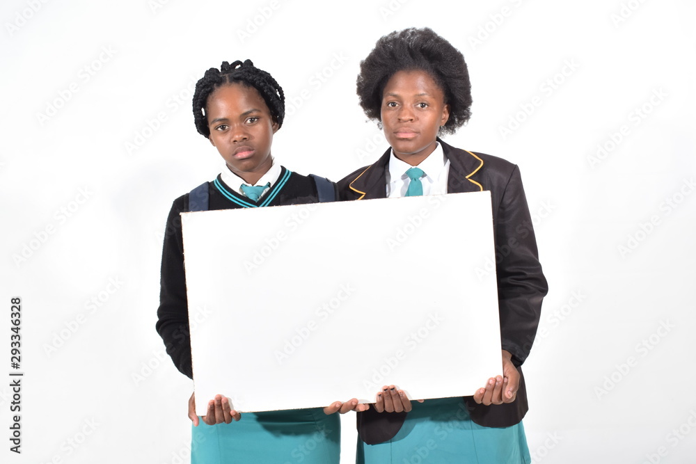happy beautiful school girls with backpack isolated on white background holding a white board happy beautiful school girls with backpack isolated on white background holding a white board