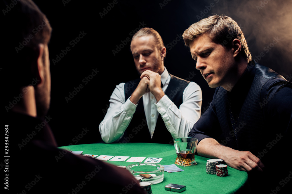 back view of man near player and croupier on black with smoke back view of man near player and croupier on black with smoke