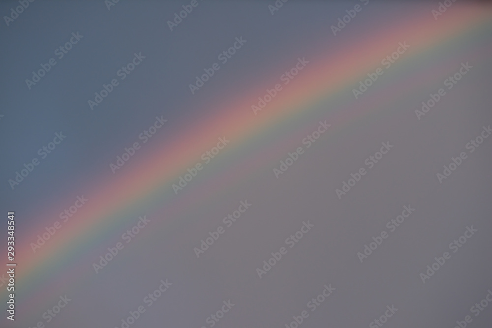 Cloudy sky after rain. Close-up of rainbow.