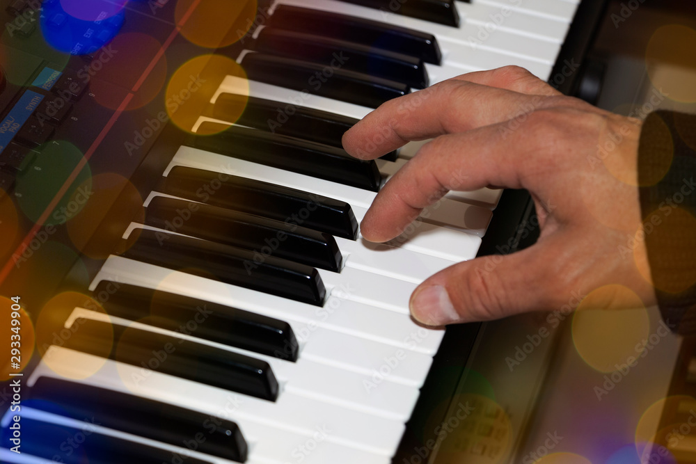 Obraz premium Hands on the piano keyboard electronic organ close-up. Hands of musician play on the piano.