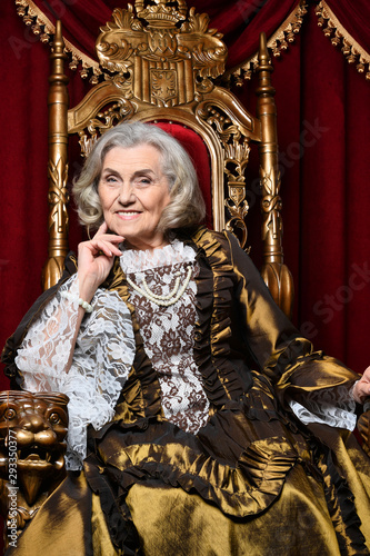 Portrait of beautiful senior queen on throne