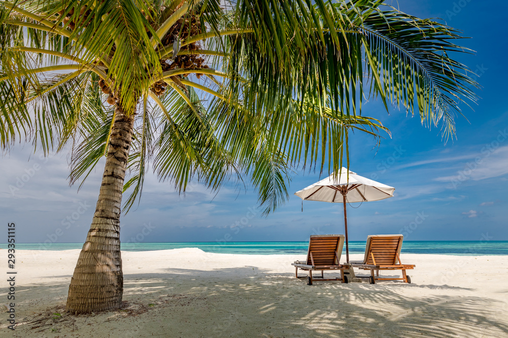 Obraz premium Beach landscape, chairs and umbrella next to palm tree on white sand. Peaceful tropical nature landscape. Calmness beach, luxury vacation and travel concept