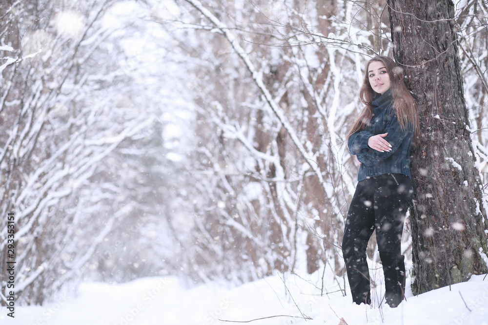 Girl in a winter park in snowfall