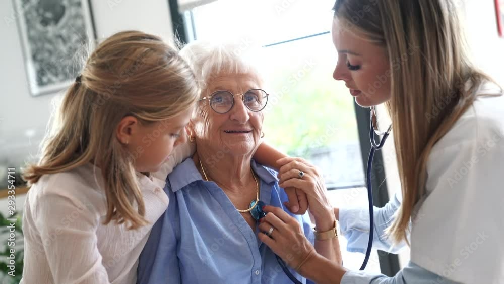 Nurse checking on elderly woman heartbeat Nurse checking on elderly woman heartbeat