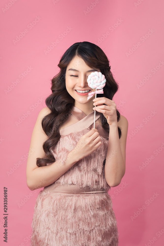asian young beautiful woman smiling, covering her eye with lollipop asian young beautiful woman smiling, covering her eye with lollipop