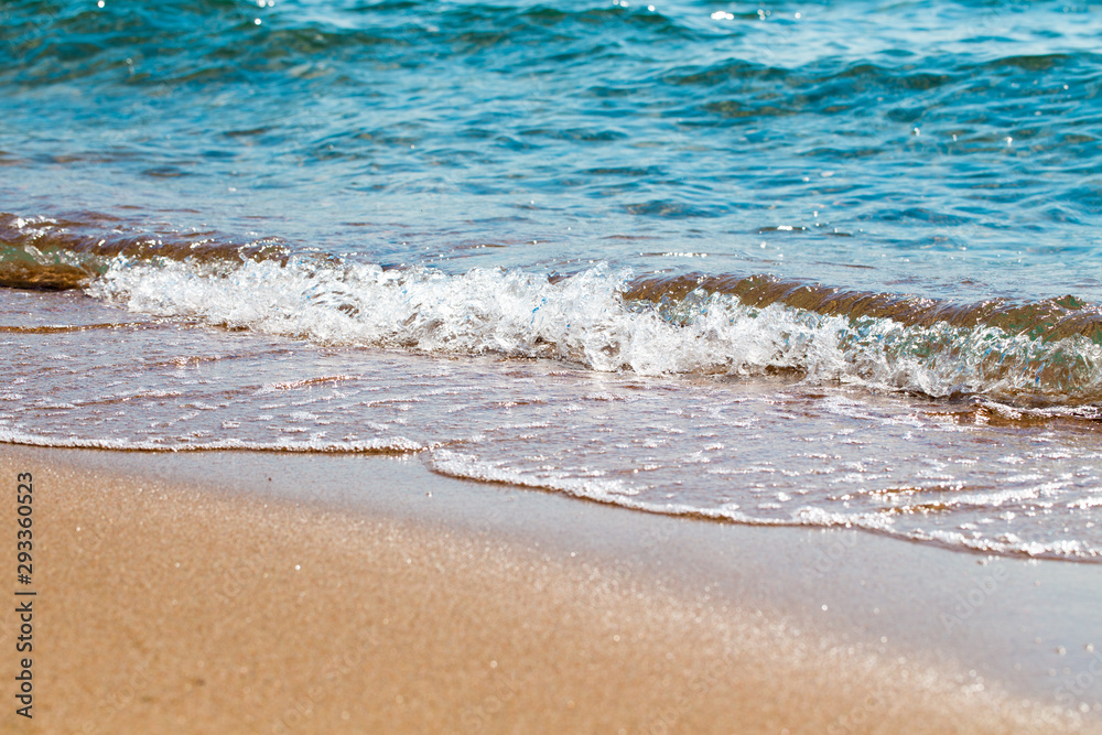 sandy beach and blue sea wave. Beautiful natural background. Tourism and travel.