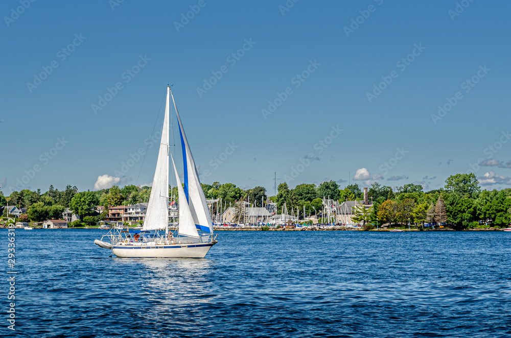 Sailboat sailing past yacht club shoreline Sailboat sailing past yacht club shoreline