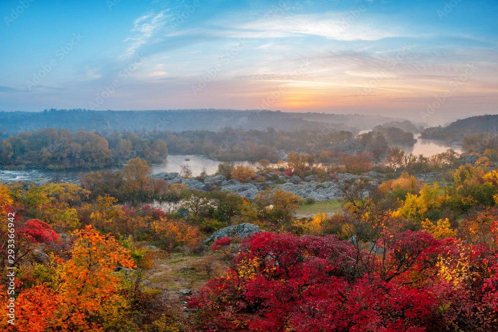 beautiful autumn landscape with colorful trees and foggy river on sunset