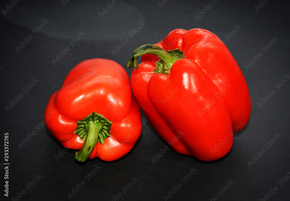 Bell pepper on black background. Two red peppers. Isolated backdrop. Macro. Closeup. Vegetables. Organic food. Bell pepper on black background. Two red peppers. Isolated backdrop. Macro. Closeup. Vegetables. Organic food.