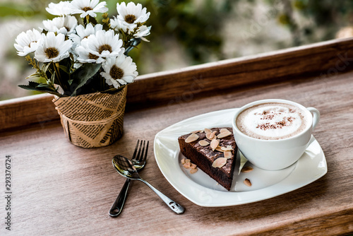  White coffee mugs and flower vases on a wooden table.Morning coffee in warm tones.