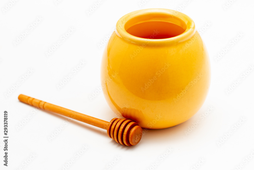 yellow pot of honey and wooden honey dipper yellow pot of honey and wooden honey dipper