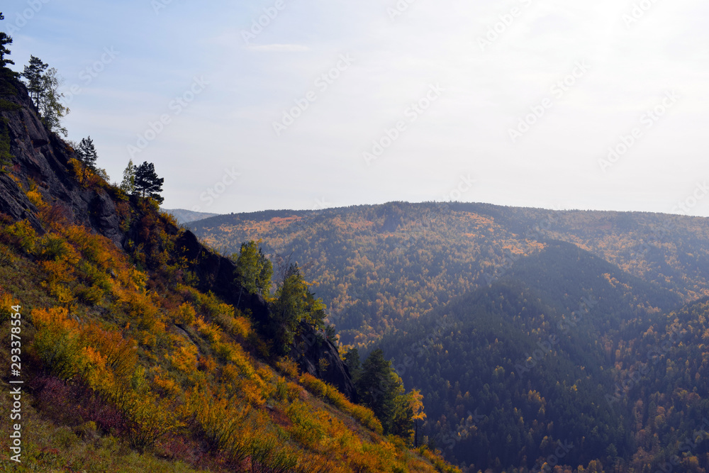 Reserve in the Krasnoyarsk region. Beautiful Siberian nature. Autumn forest. Panoramic view of the high mountains. Fascinating landscape.