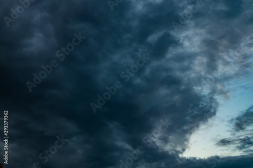 dark Blue sky background with evening fluffy curly rolling altocumulus altostratus clouds