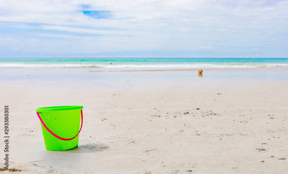 Plastic Kids Bucket for making sandcastles on a sandy beach Plastic Kids Bucket for making sandcastles on a sandy beach