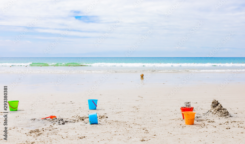 Plastic Kids Bucket for making sandcastles on a sandy beach Plastic Kids Bucket for making sandcastles on a sandy beach