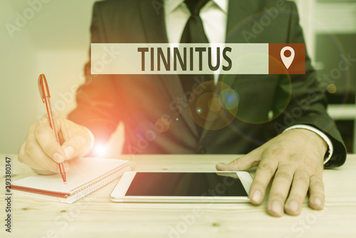 Writing note showing Tinnitus. Business concept for A ringing or music and similar sensation of sound in ears photo