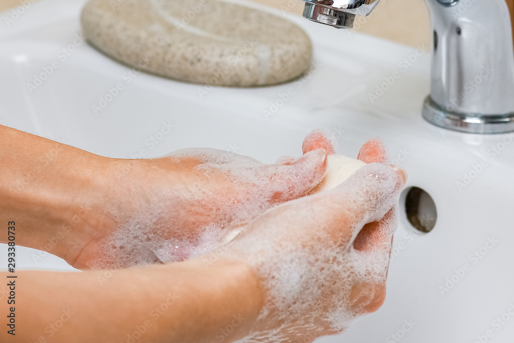 Fototapeta premium Hygiene concept. Washing hands with soap under the faucet with water