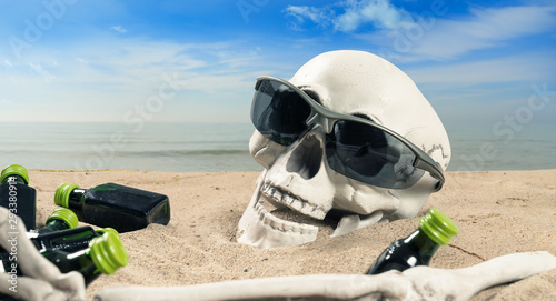 concept about alcohol addiction a skeleton with a alcohol lies on the beach