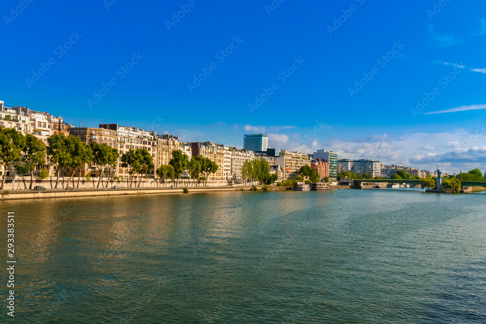 Beautiful panoramic view of the Quai Louis-Blériot, a quay alongside the Seine river in the 16th arrondissement of Paris, France on a nice day with a blue sky. The Île aux Cygnes can be seen from far.