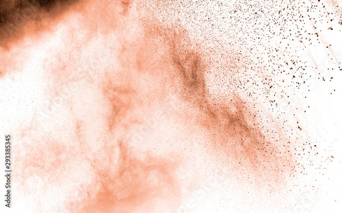 Abstract light orange powder explosion on white background. Freeze motion of light orange dust particles splash.