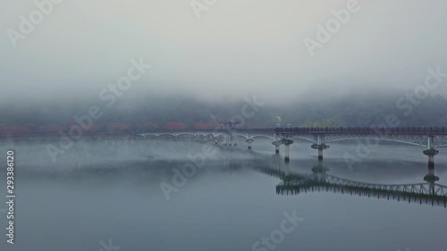 Aerial video of Wolyeonggyo bridge is located in the midst of Nakdong river in the morning during Autumn season at Andong city, South Korea. photo